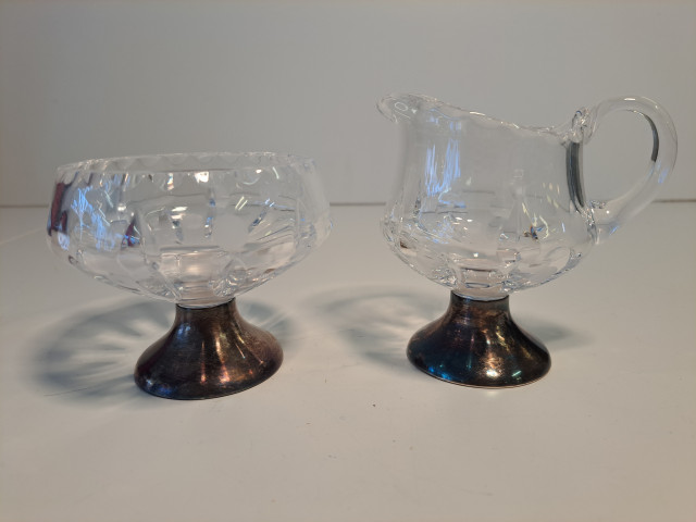 Kristalliset sokerikko ja kermakko hopeajaloilla