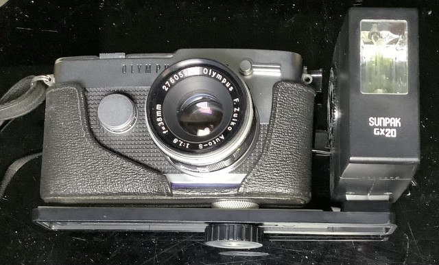 Olympus pen F kinofilmikamera ja Sunppak gx20 salamalaite kiinnityskiskolla.