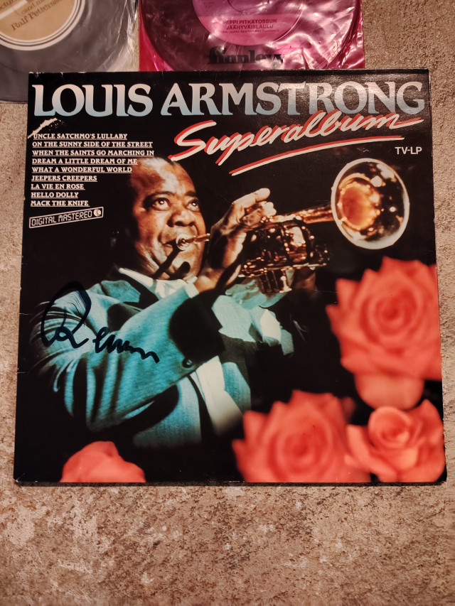 Single levyjä ja Remun allekirjoituksella Louis Armstrongin Lp levy