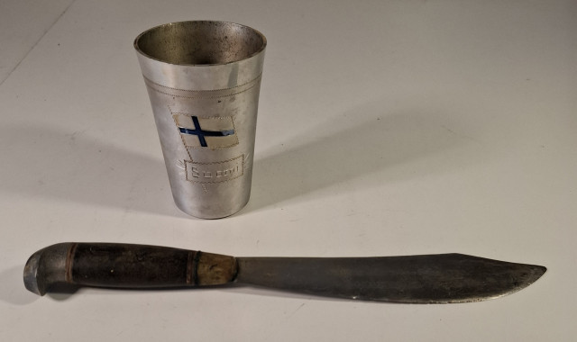 Vanha puukko tekstillä ja Suomi tinatuoppi