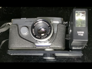 Olympus pen F kinofilmikamera ja Sunppak gx20 salamalaite kiinnityskiskolla.
